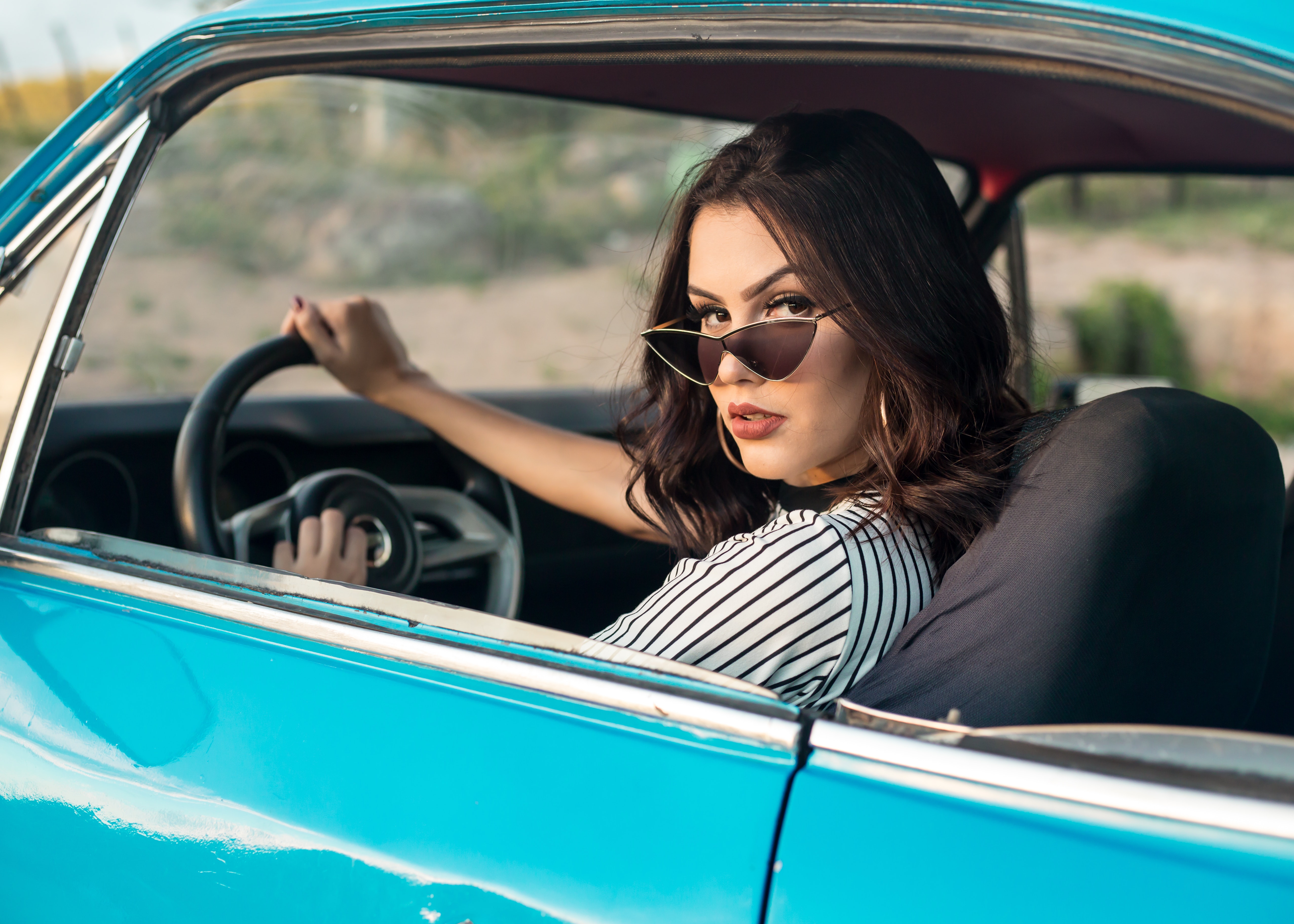 female driver in shades looking back